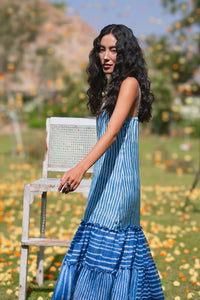 Woman in a blue tiered dress standing outdoors with blurred background - HeenaAgrima