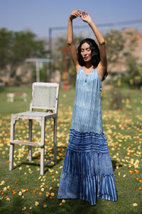 Woman in a blue tiered dress standing outdoors with blurred background - HeenaAgrima