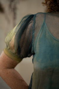 Close-up of a person wearing a sheer top with a blurred background