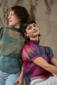 Two women wearing HeenaAgrima's Amethyst Silk Organza  tops sitting close together against a neutral background.