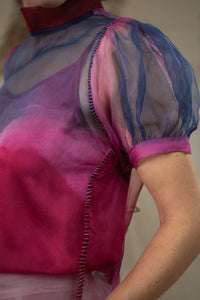 Close-up of a Woman wearing HeenaAgrima's Amethyst Silk Organza Top, a sheer, multicolored top with a blurred natural background