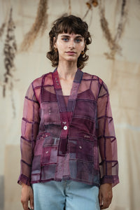 Woman wearing HeenaAgrima's Purple Dream Silk Organza Jacket, a sheer purple jacket over a dark top with light blue jeans against a neutral background