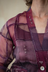 Close-up of a Woman wearing HeenaAgrima's Purple Dream Silk Organza Jacket, a sheer purple jacket over a dark top with light blue jeans against a neutral background