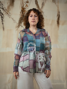 Woman wearing Stormy 2.0 patchwork shirt a colorful, patterned shirt with a neutral background