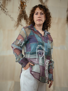 Woman wearing Stormy 2.0 patchwork shirt a colorful, patterned shirt with a neutral background