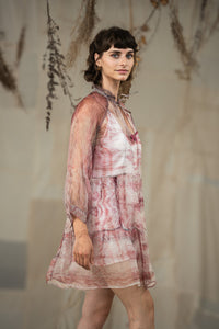 Woman wearing HeenaAgrima's black current organza dress, a sheer, patterned dress against a neutral background. 