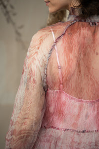 Close-up of a person wearing, HeenaAgrima's black current organza dress, a pink and white patterned garment.