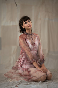 Woman in HeenaAgrima's black current organza dress, a patterned dress sitting on the ground against a plain background