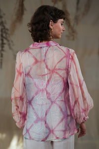 Back of a Woman wearing HeenaAgrima's pink quartz shirt, a pastel tie-dye pink shirt with a blurred background