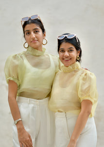 Two women wearing matching light yellow tops with sheer sleeves against a white background - OG Fallon Organza Shirt by HeenaAgrima