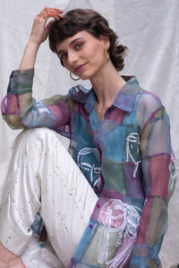 Woman wearing a HeenaAgrima's colorful, patterned blouse with a white background. 