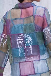 HeenaAgrima's sheer patchwork shirt with embroidered faces on a white background. 