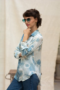 Woman wearing HeenaAgrima's Blu Shibo Shirt, a blue and white patterned shirt with sunglasses and hoop earrings.