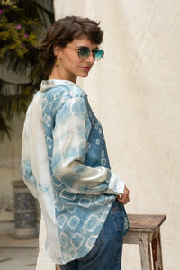 Woman wearing HeenaAgrima's Blu Shibo Stain Silk Shirt, a blue and white patterned shirt with sunglasses and hoop earrings.