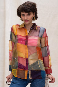 Woman wearing HeenaAGrima's OG Indradhanush Shirt, a colorful patchwork shirt against a white blurred background. 