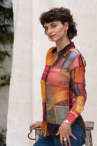 Woman wearing HeenaAGrima's OG Indradhanush Shirt, a colorful patchwork shirt against a white blurred background. 
