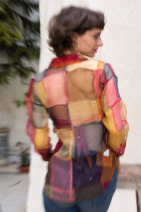 Woman wearing HeenaAGrima's OG Indradhanush Shirt, a colorful patchwork shirt against a white blurred background. 