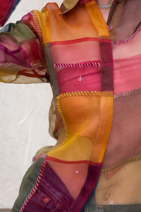 Close-up of Woman wearing HeenaAGrima's OG Indradhanush Shirt, a colorful patchwork shirt against a white blurred background. 