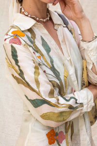 Close-up of a person wearing a floral embroidered shirt named as Garden shirt by HeenaAgrima with a white background. 