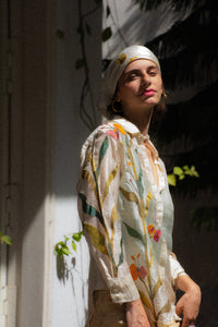 Woman wearing a floral embroidered shirt named as Garden shirt by HeenaAgrima with a white and green background. 