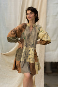 Woman wearing HeenaAgrima's Venus Handloom Cotton Dress patchwork dress with a floral pattern against a draped fabric background