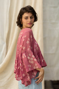Woman wearing a pink patterned cotton blouse, named love bug top made by HeenaAgrima. 