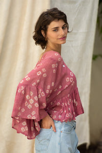 Woman wearing a pink patterned cotton blouse, named love bug top made by HeenaAgrima. 