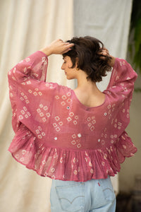 Woman wearing a pink patterned cotton blouse, named love bug top made by HeenaAgrima. 
