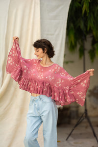 Woman wearing a pink patterned cotton blouse, named love bug top made by HeenaAgrima. 