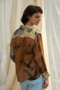 Woman wearing HeenaAgrima Eath linen Shirt, a patterned shirt and light, dyed with iron, cutch, and myrobalan against a neutral background