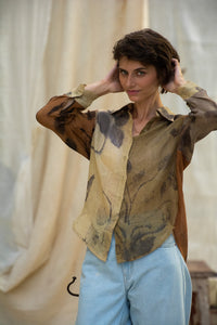 Woman wearing HeenaAgrima Eath linen Shirt, a patterned shirt and light, dyed with iron, cutch, and myrobalan against a neutral background