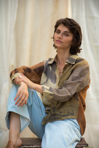 Woman wearing HeenaAgrima Eath linen Shirt, a patterned shirt and light, dyed with iron, cutch, and myrobalan against a neutral background. 