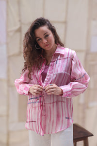 Woman wearing HeenaAgrima's Candy Cane Organza Shirt, a pink striped shirt with a blurred background. 