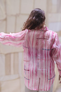 Woman wearing HeenaAgrima's Candy Cane Organza Shirt, a pink striped shirt with a blurred background. 