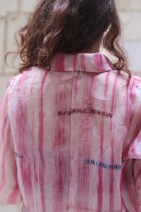 Woman wearing HeenaAgrima's Candy Cane Organza Shirt, a pink striped shirt with a blurred background. 
