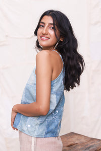 Woman wearing a tank top with a plain background