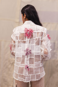 Woman wearing heenaAgrima Snow Blossom Organza Shirt, a white sheer shirt with floral embroidery against a neutral background