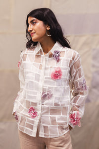 Woman wearing heenaAgrima Snow Blossom Organza Shirt, a white sheer shirt with floral embroidery against a neutral background