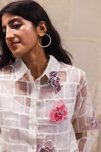 Woman wearing heenaAgrima Snow Blossom Organza Shirt, a white sheer shirt with floral embroidery against a neutral background