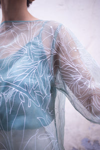 Sheer top with floral pattern on a blurred background
