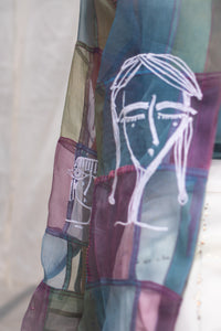 Woman wearing a HeenaAgrima's colorful, patchwork-style shirt, named Stormy against a plain background