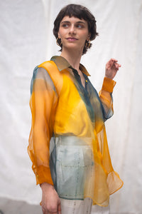 Woman wearing HeenaAgrima's Meadow Silk Organza Shirt, a sheer orange and green Shirt sitting against a white background. 