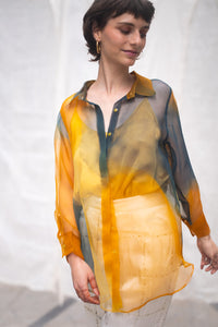 Woman wearing HeenaAgrima's Meadow Silk Organza Shirt, a sheer orange and green Shirt sitting against a white background