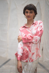 Woman wearing a pink and white tie-dye shirt against a neutral background
