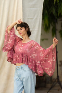 Woman wearing a pink patterned blouse, named love bug top made by HeenaAgrima. 